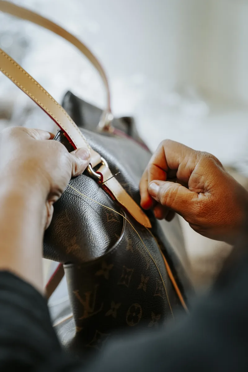 Costura manual da alça de uma bolsa Louis Vuitton