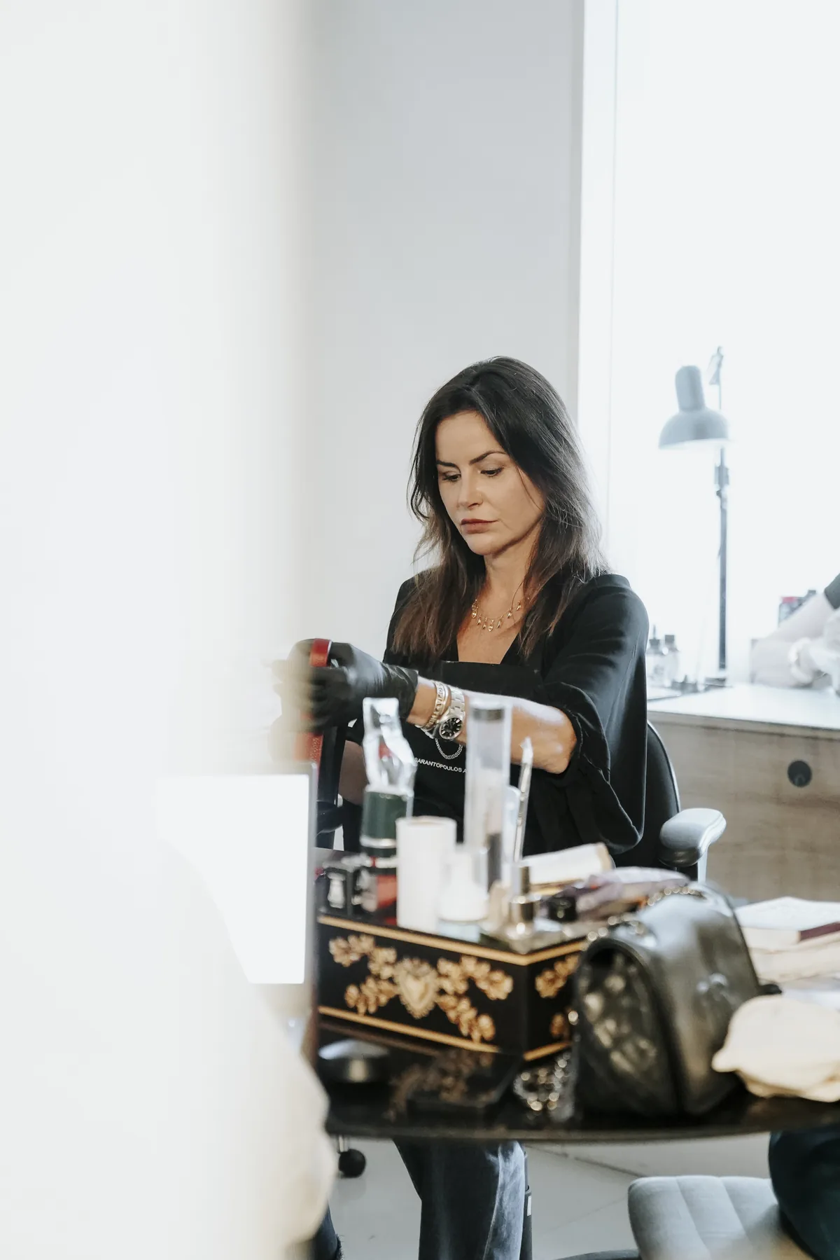 Nicole Sarantopoulos trabalhando em uma peça na bancada do ateliê